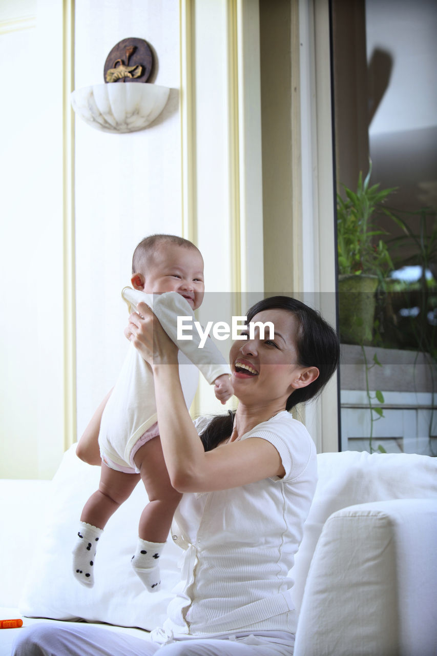 Close-up of mother carrying daughter at home