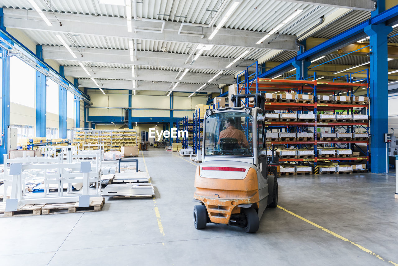 Man on forklift in factory warehouse