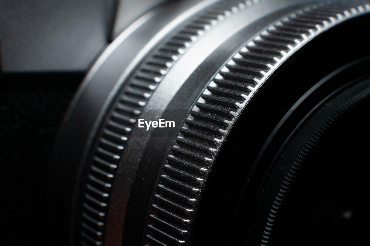 technology, camera lens, camera, close-up, equipment, black and white, lens - optical instrument, indoors, single object, no people, wheel, black, arts culture and entertainment, monochrome, photographic equipment, retro styled, extreme close-up, industry, selective focus, lens - eye, macro, focus on foreground