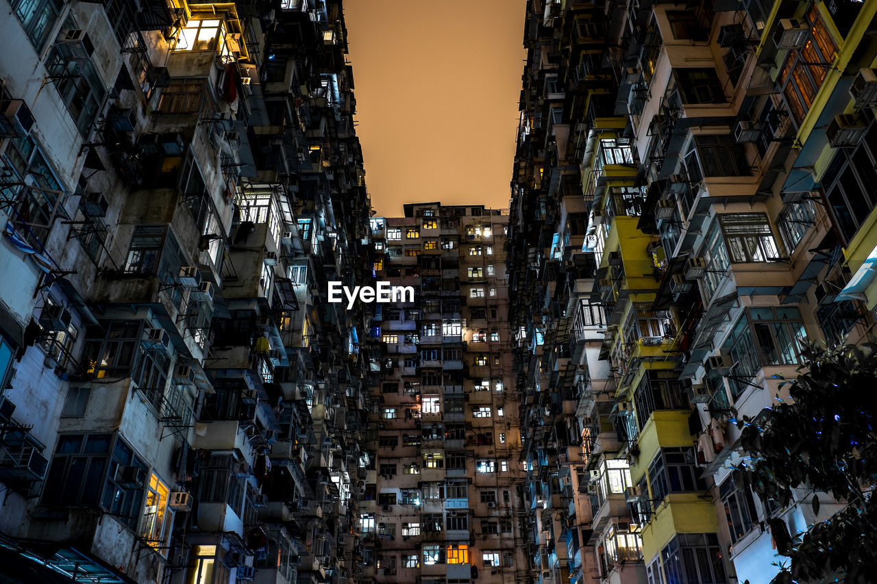 Low angle view of buildings in city at dusk