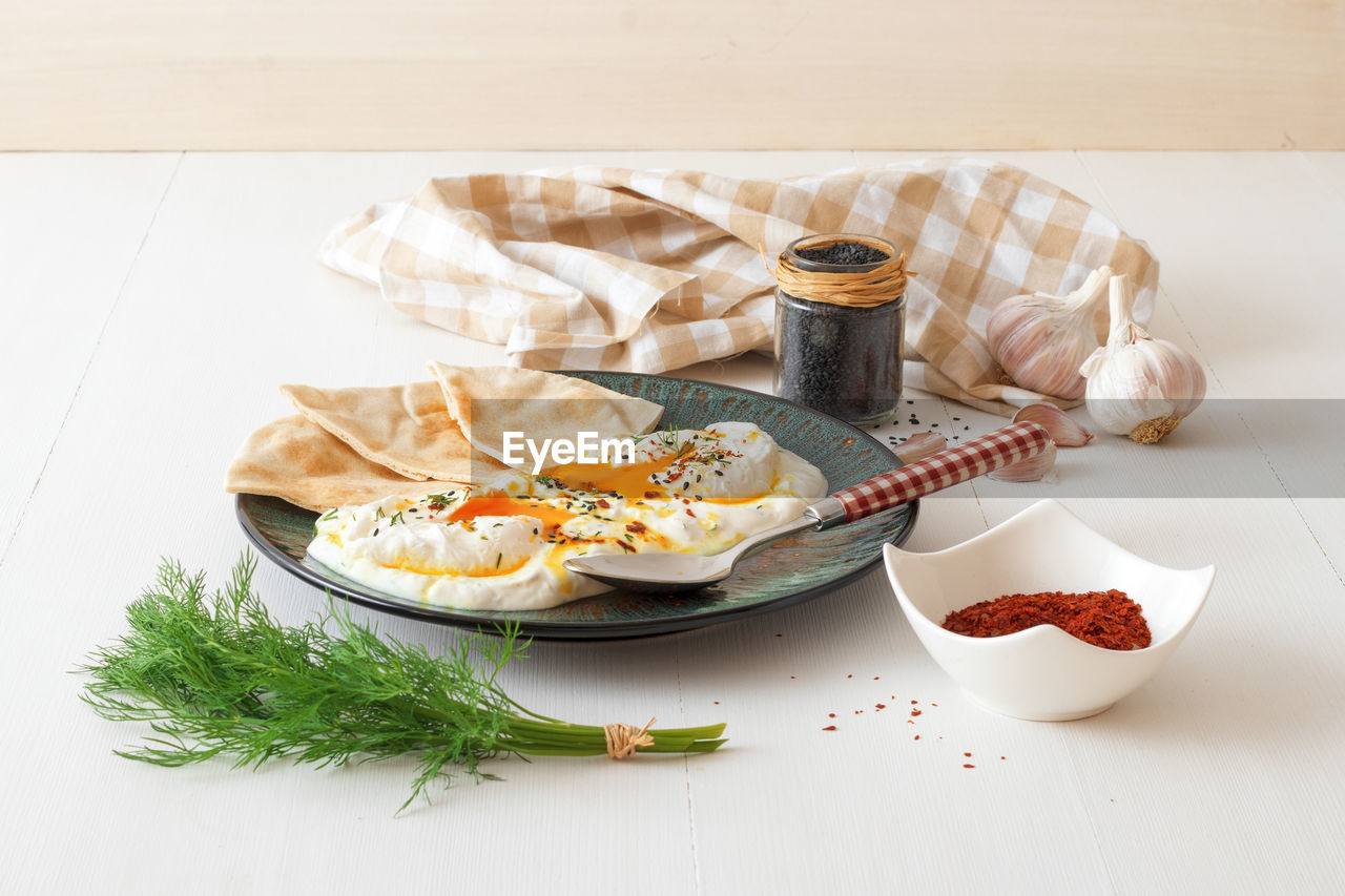Turkish eggs cilbir, plain yogurt, poached eggs, garlic, chilli, fresh dill and melted butter. 