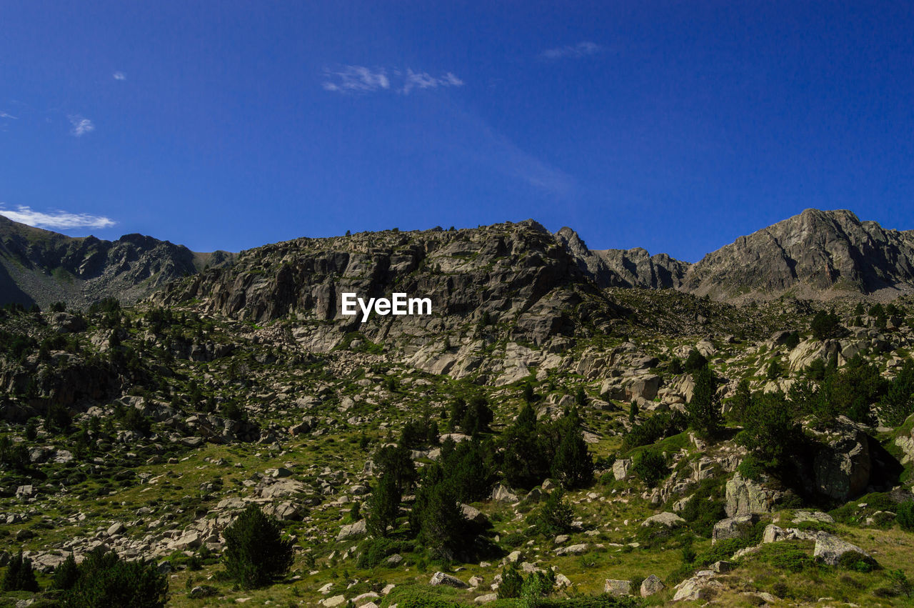 Scenic view of rocky mountains against blue sky