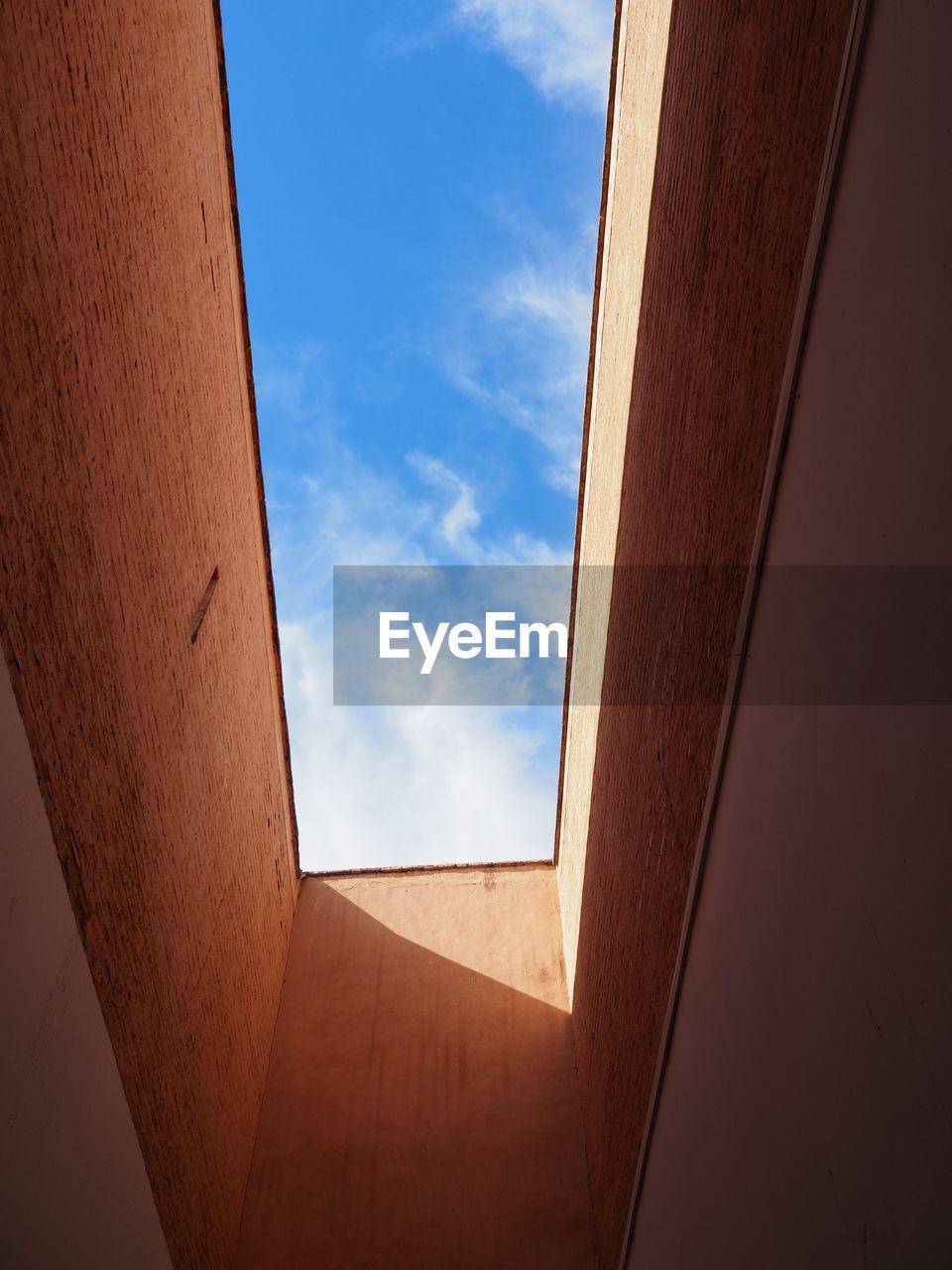 Low angle view of skylight in building against sky