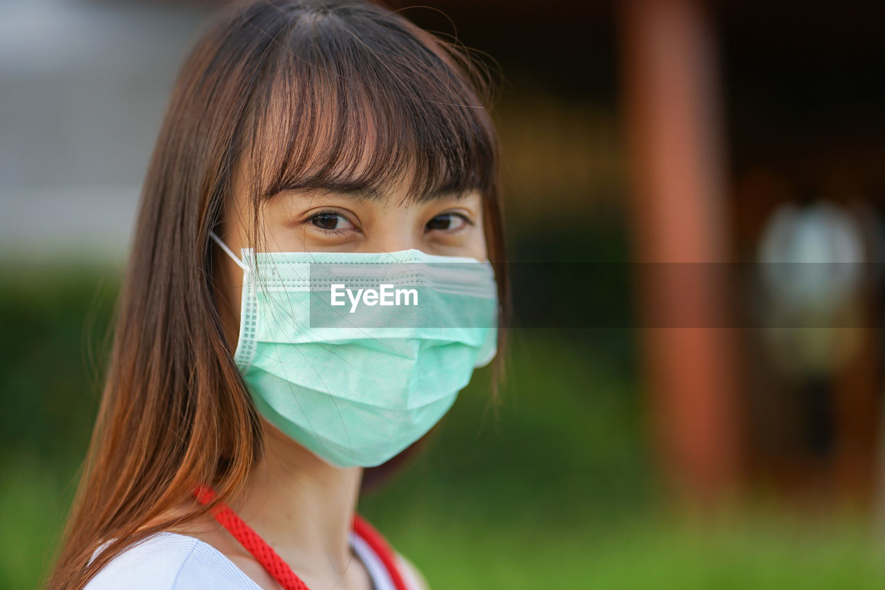 CLOSE-UP PORTRAIT OF WOMAN WEARING MASK OUTDOORS