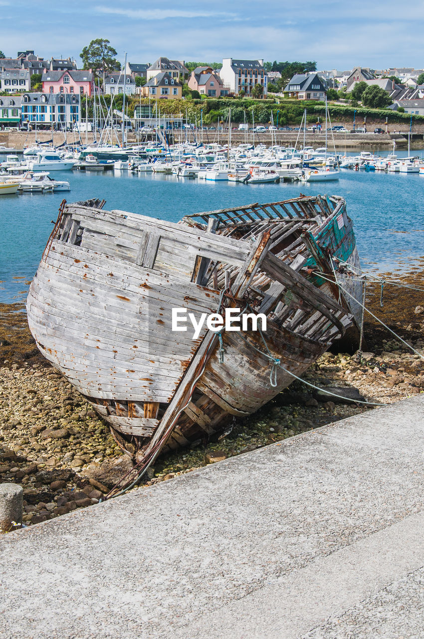 BOATS MOORED ON SHORE AGAINST SEA