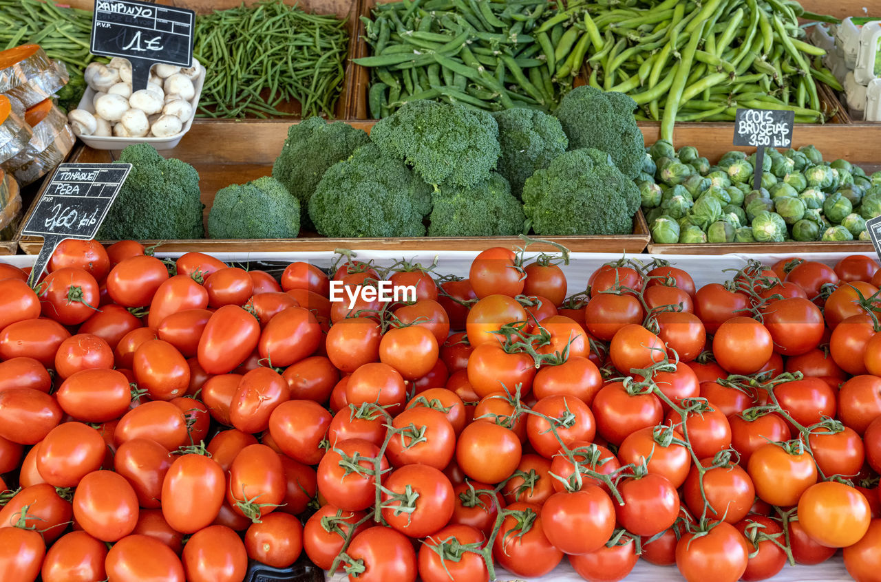 Tomatoes, broccoli and green peas for sale at a market