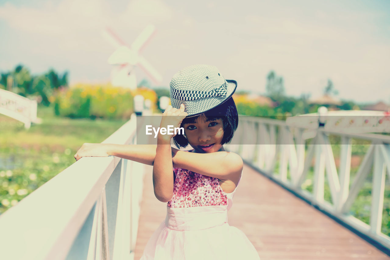 Girl looking away while standing on railing