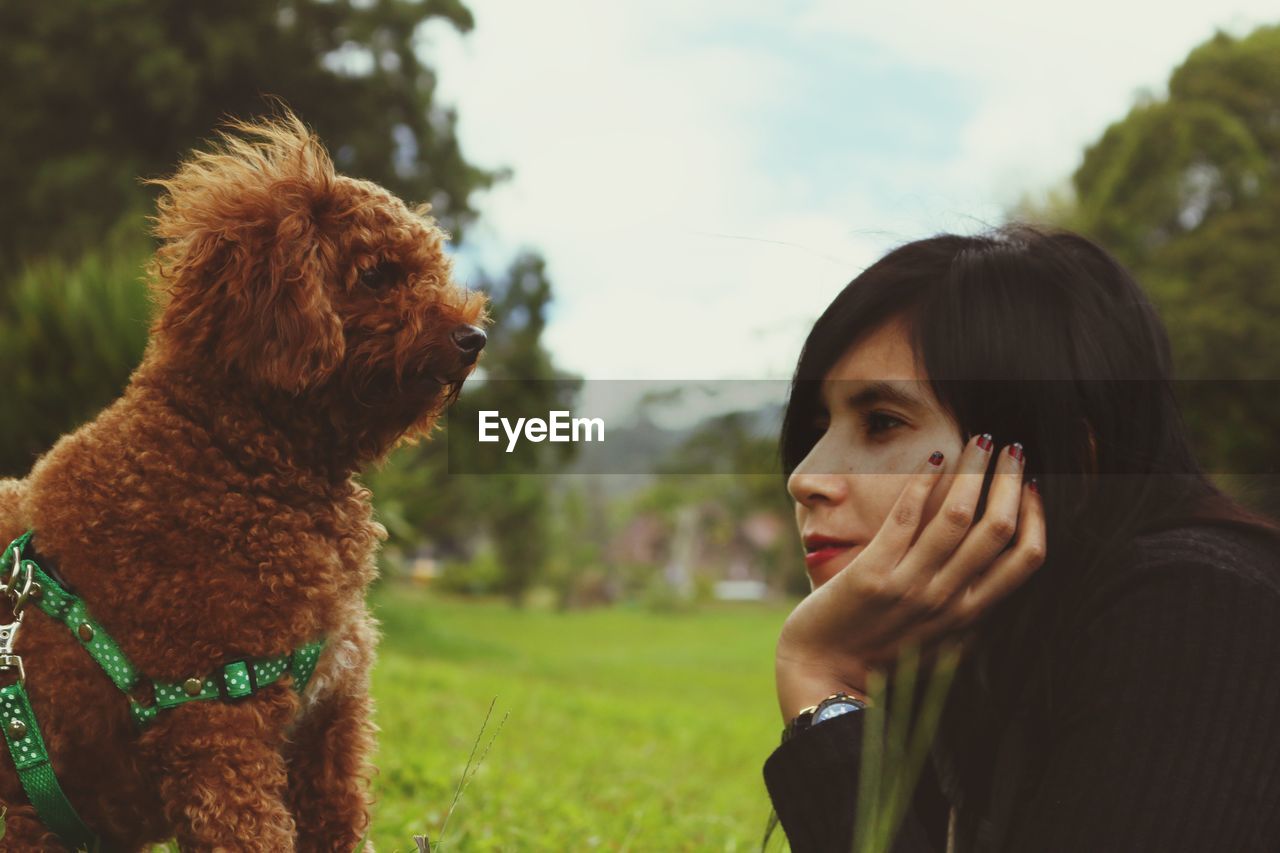 Woman looking at dog on land 