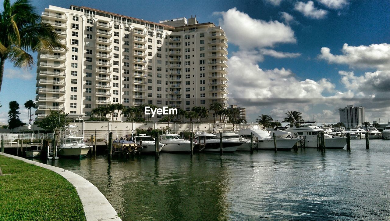 Boats moored at harbor against building