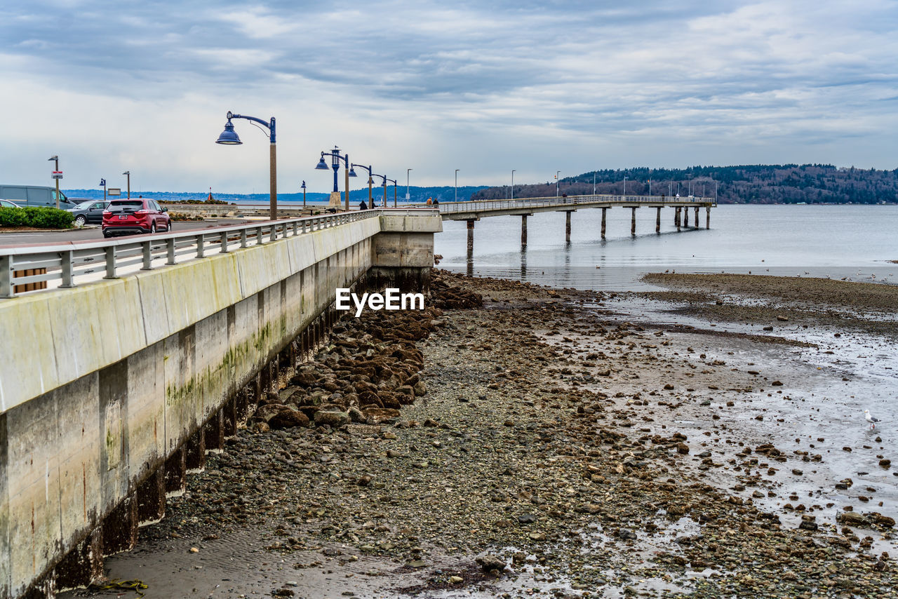 water, walkway, coast, sky, sea, architecture, pier, shore, built structure, nature, beach, cloud, land, transportation, bridge, environment, ocean, travel destinations, travel, waterway, boardwalk, body of water, scenics - nature, no people, outdoors, city, coastline, day, landscape, beauty in nature, tourism, channel, reservoir, building exterior, breakwater, environmental conservation, tranquility, sand, wave, water's edge