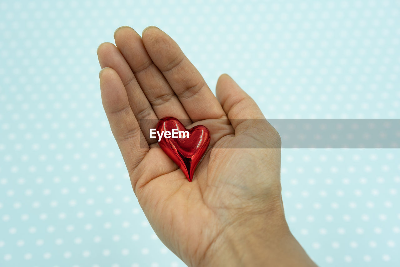 hand, finger, heart shape, red, heart, love, indoors, emotion, positive emotion, studio shot, close-up, nail, one person, blue, limb, adult, colored background, human leg