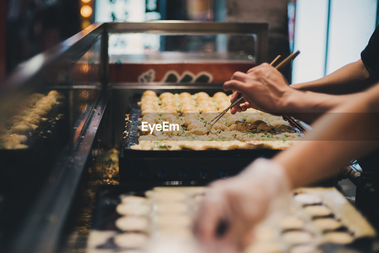 Midsection of person preparing food in kitchen