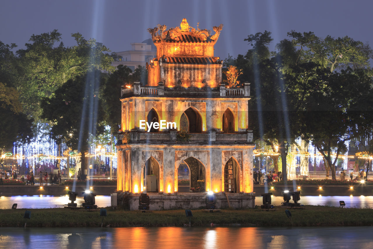 Illuminated turtle tower on hoan kiem lake at dusk