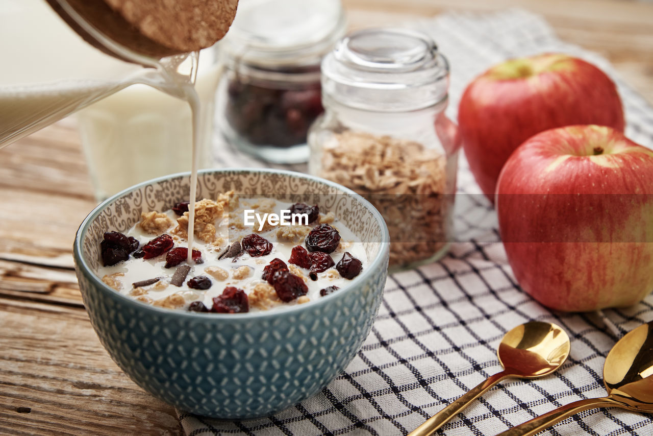 Morning breakfast with granola on wooden background