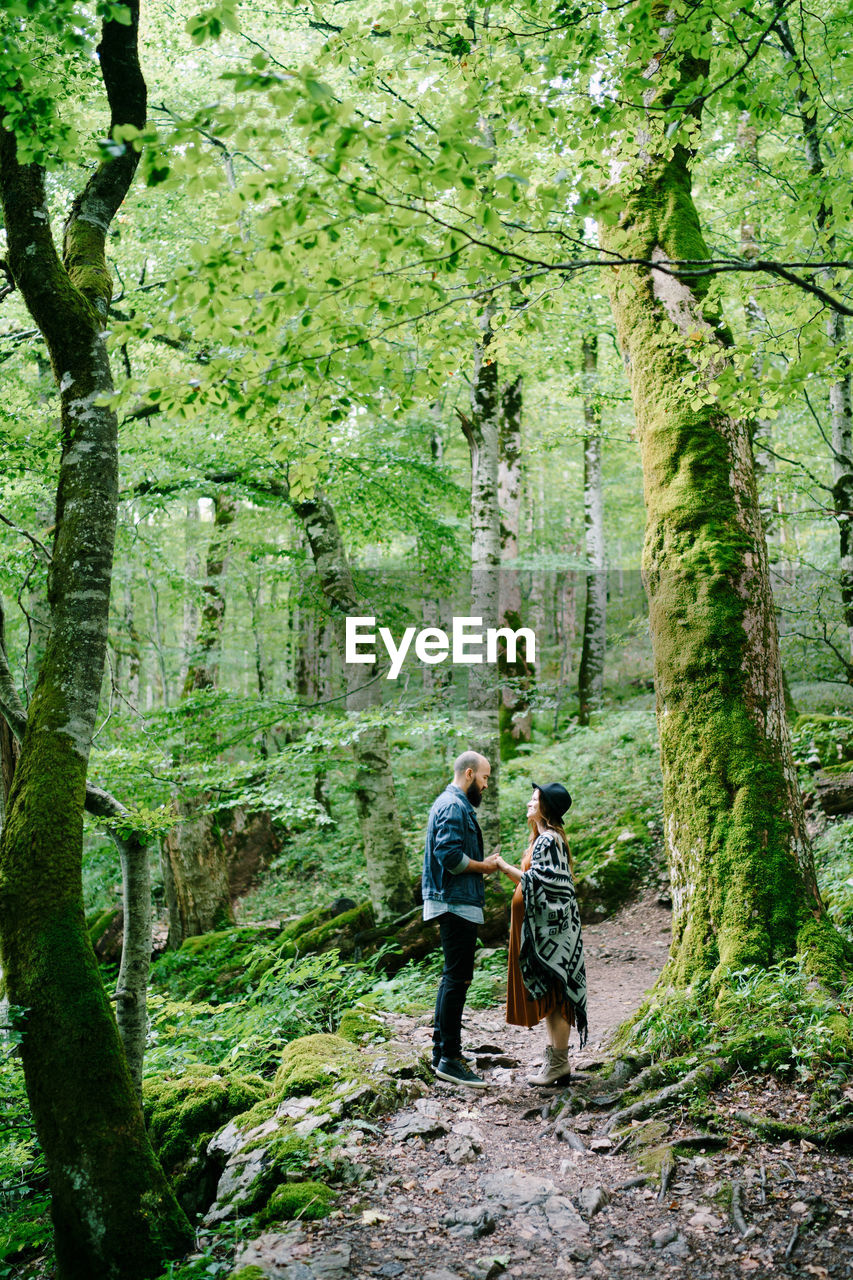 MAN AND PEOPLE ON FOOTPATH IN FOREST