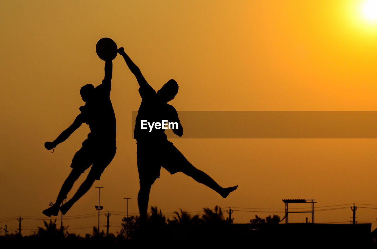 Silhouette men against sky during sunset