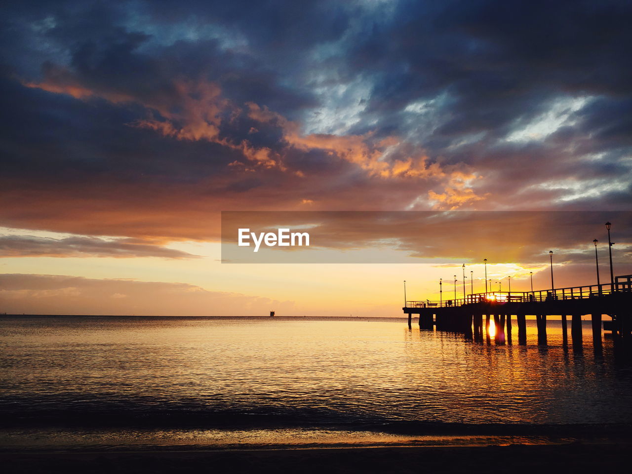 PIER OVER SEA AGAINST SKY DURING SUNSET