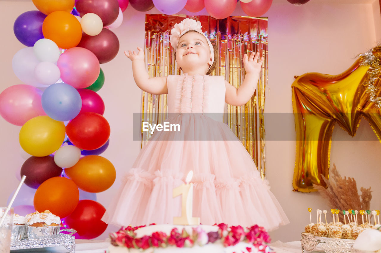 rear view of woman with balloons on table