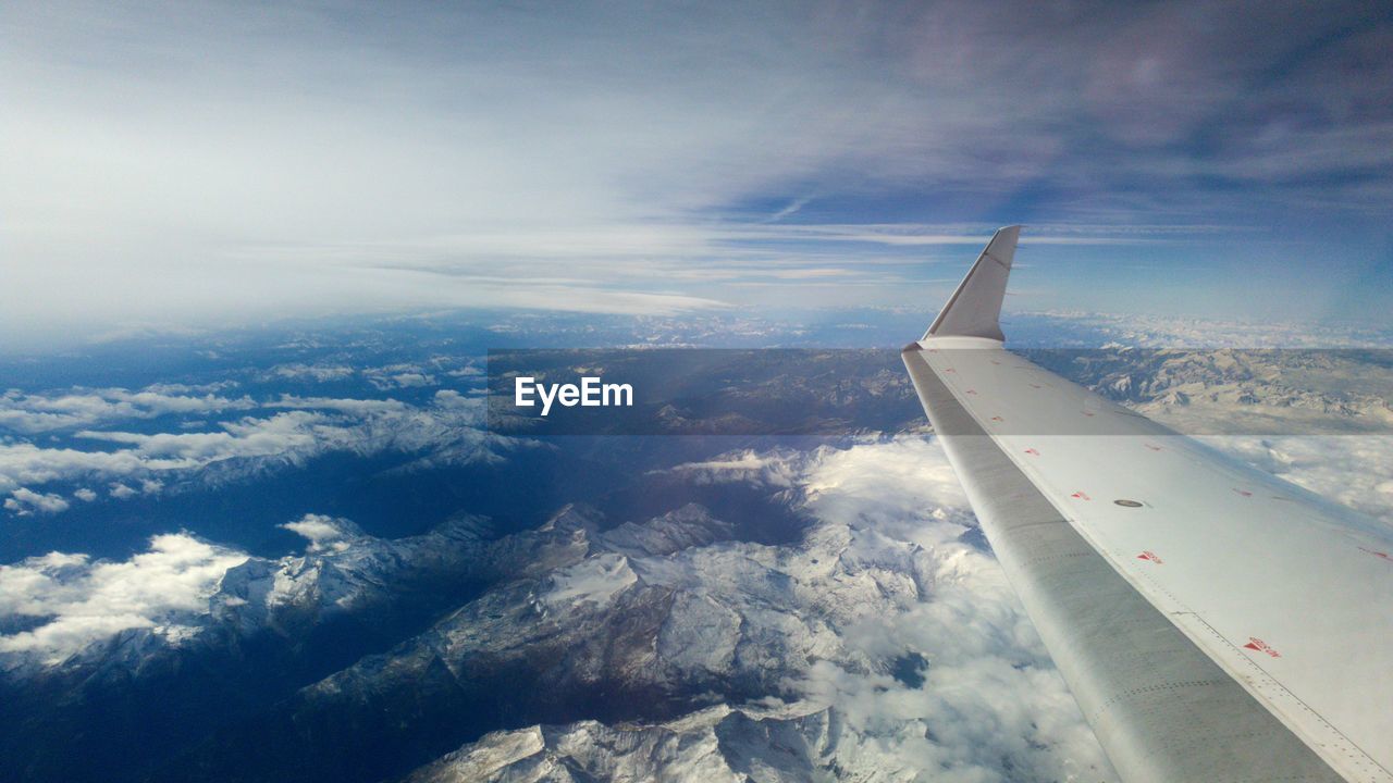 AERIAL VIEW OF AIRCRAFT WING OVER CLOUDS