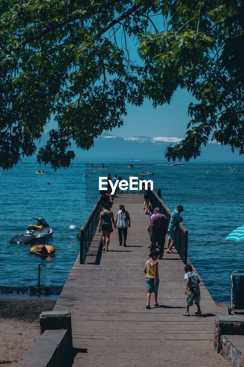 PEOPLE WALKING BY FOOTPATH AGAINST SEA