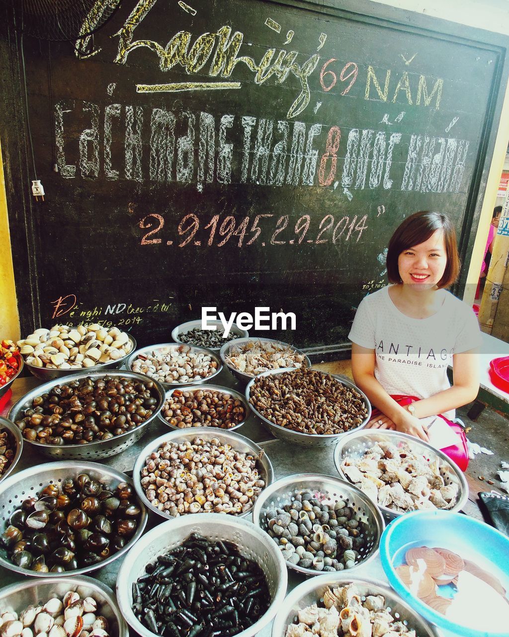 Young woman at market stall with seafood