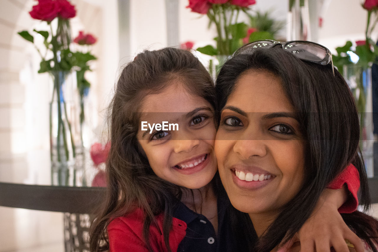 Portrait of smiling daughter embracing mother