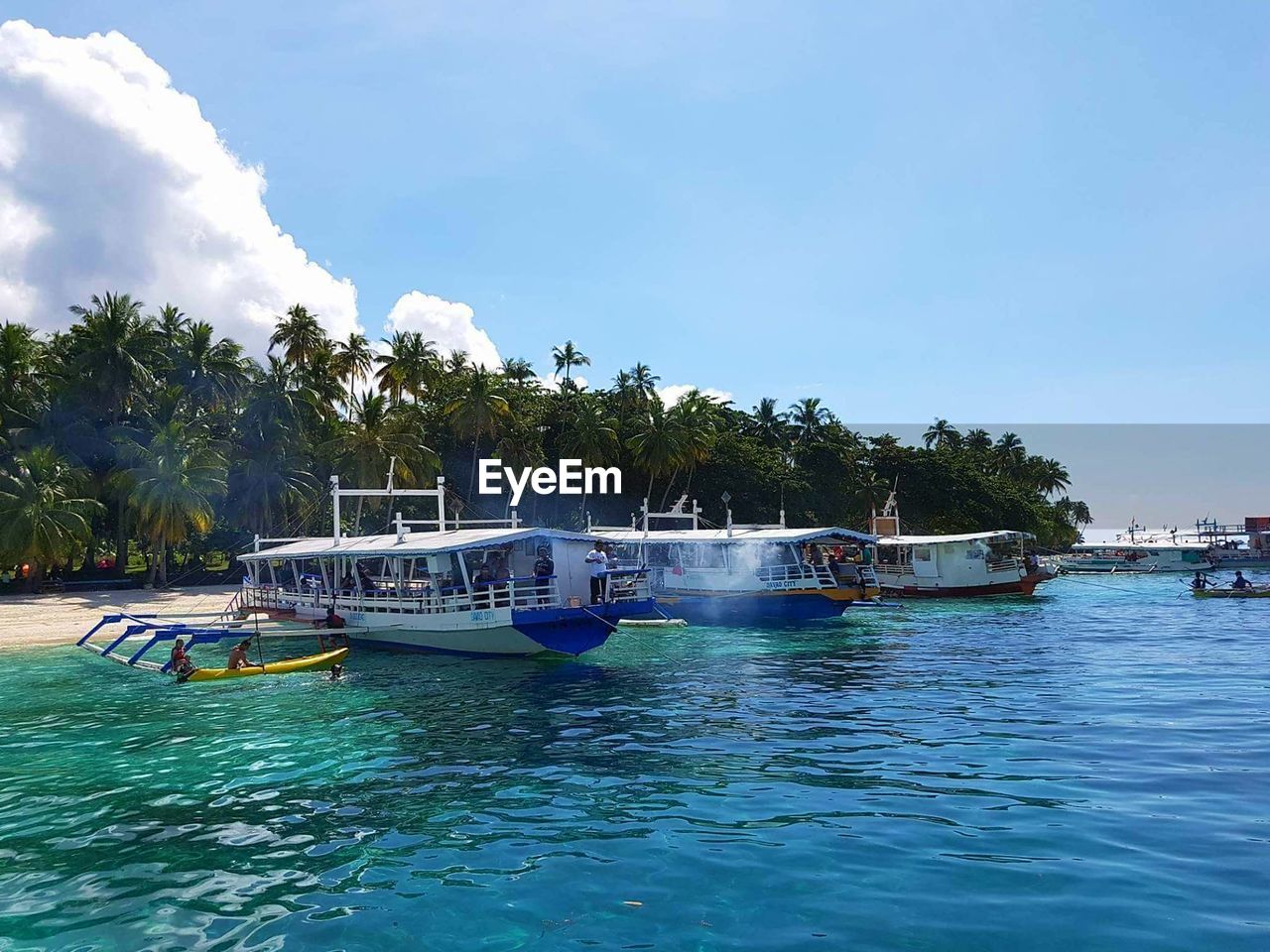 BOATS MOORED ON SEA AGAINST BLUE SKY