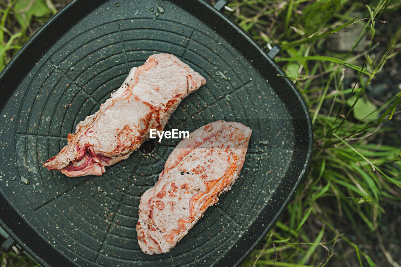 Meat steak is fried  grill pan  gas stove in open. cooking meal picnic, full-fledged nutrition