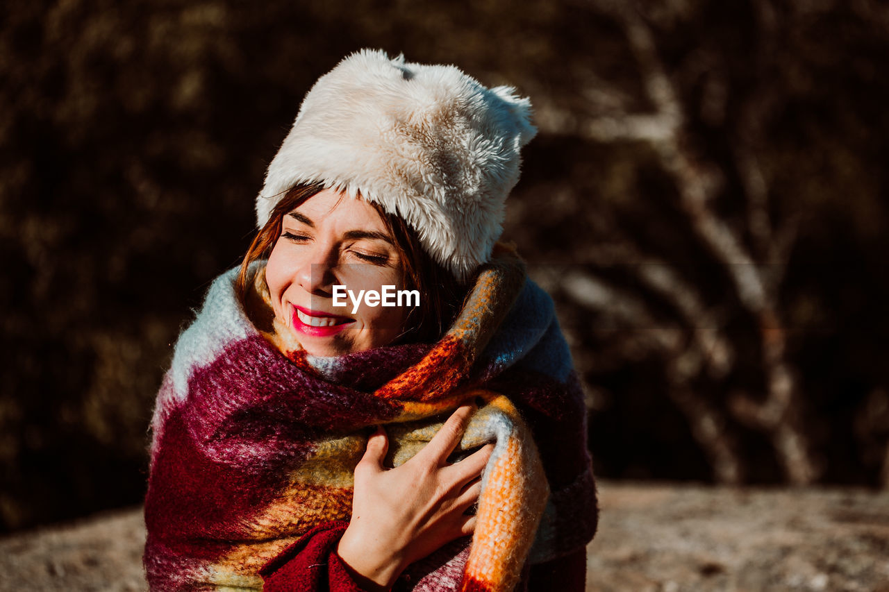 PORTRAIT OF A SMILING YOUNG WOMAN IN SNOW