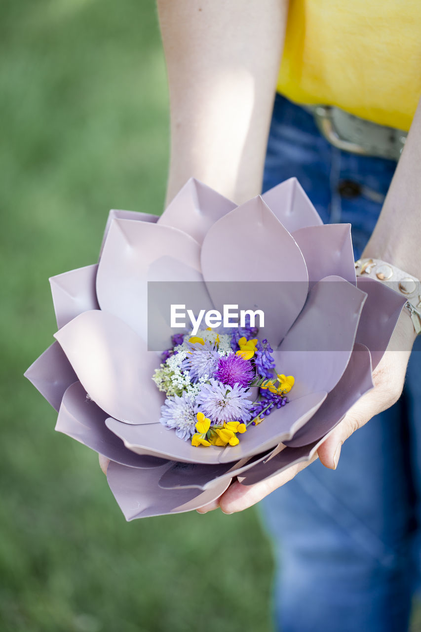 Midsection of woman with flowers