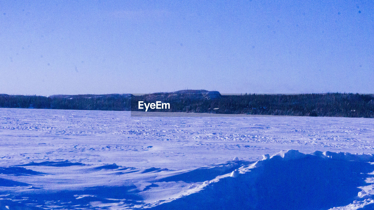 SCENIC VIEW OF FROZEN LAKE AGAINST CLEAR SKY