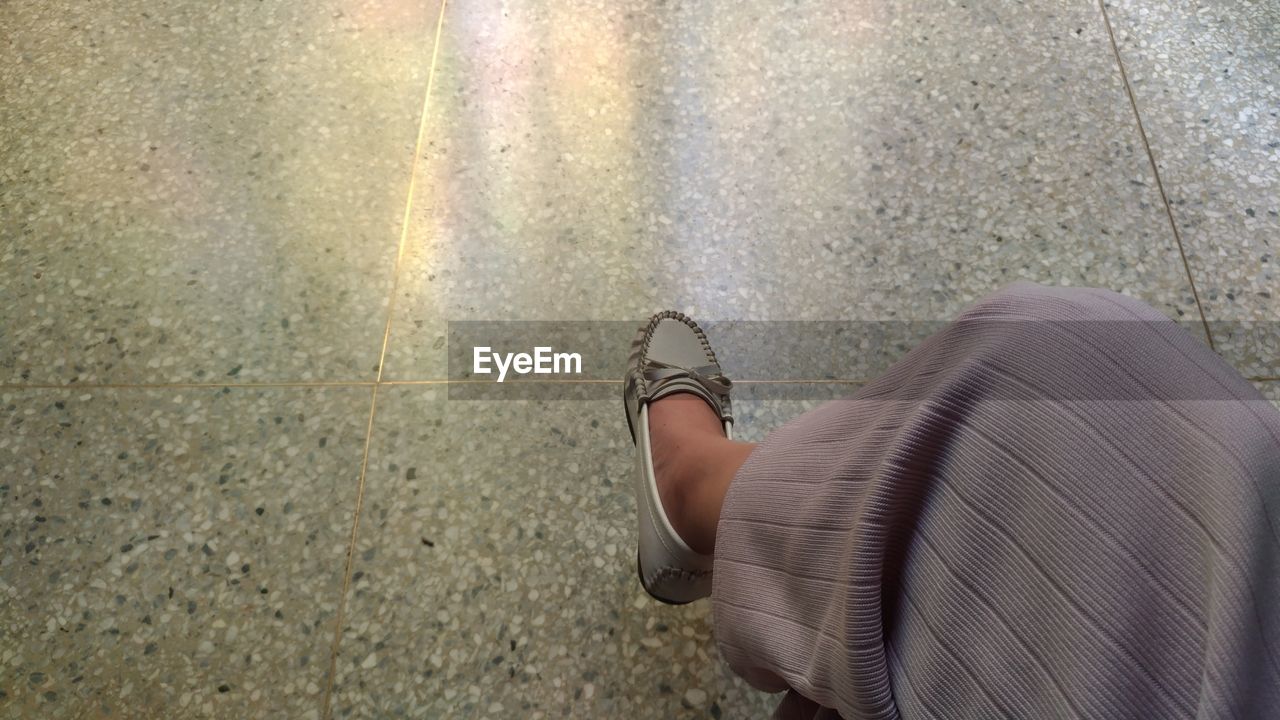 LOW SECTION OF WOMAN WALKING ON FLOOR