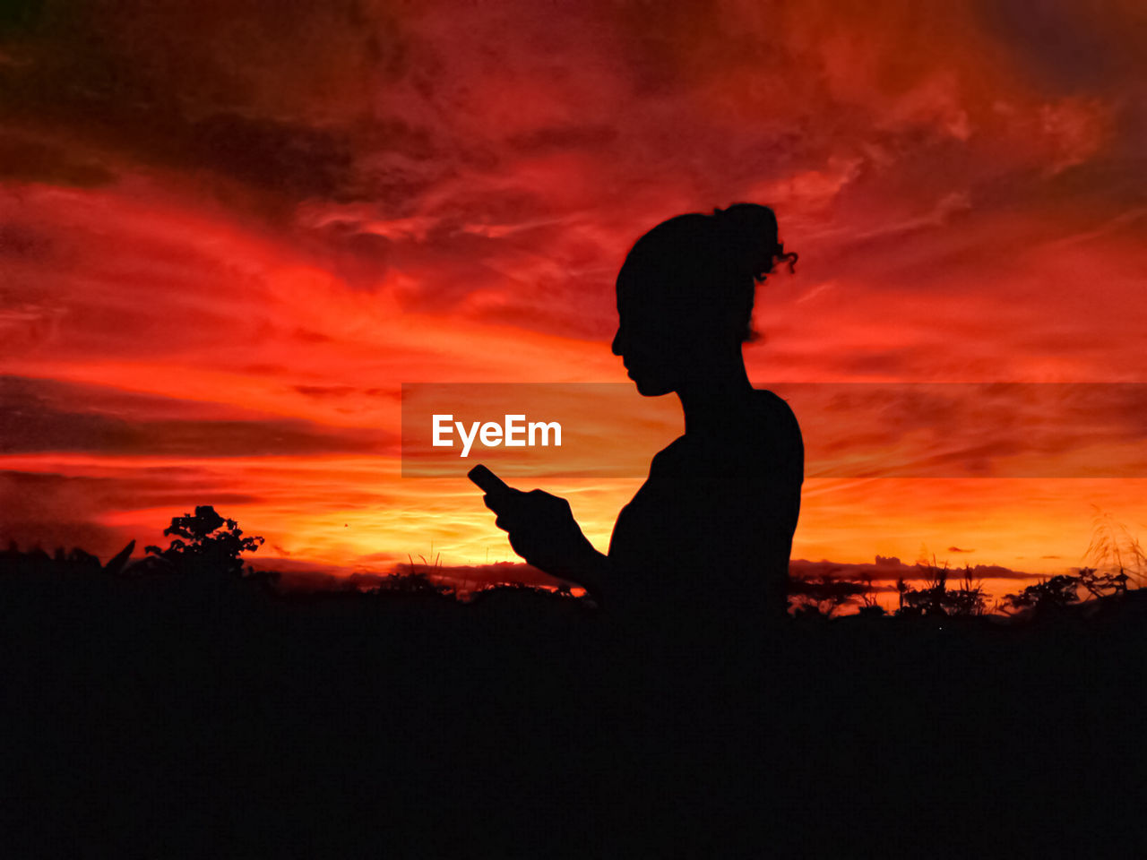 SILHOUETTE MAN STANDING AGAINST ORANGE SUNSET SKY