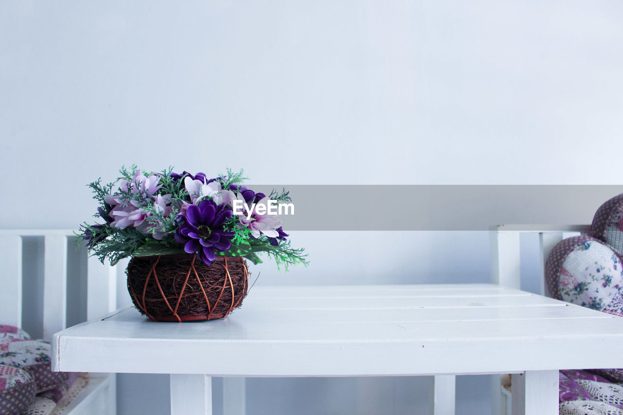 Flower pot on table against wall