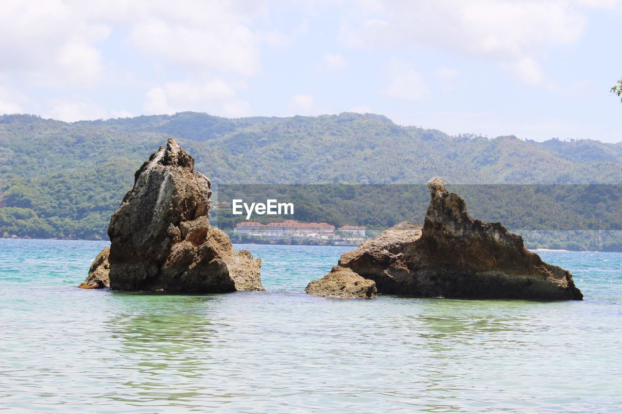 Scenic view of sea and mountains against sky