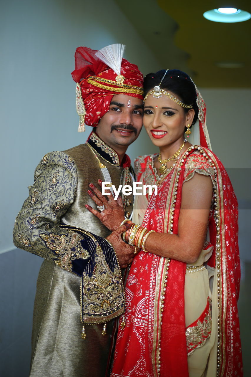 Smiling young couple standing against wall