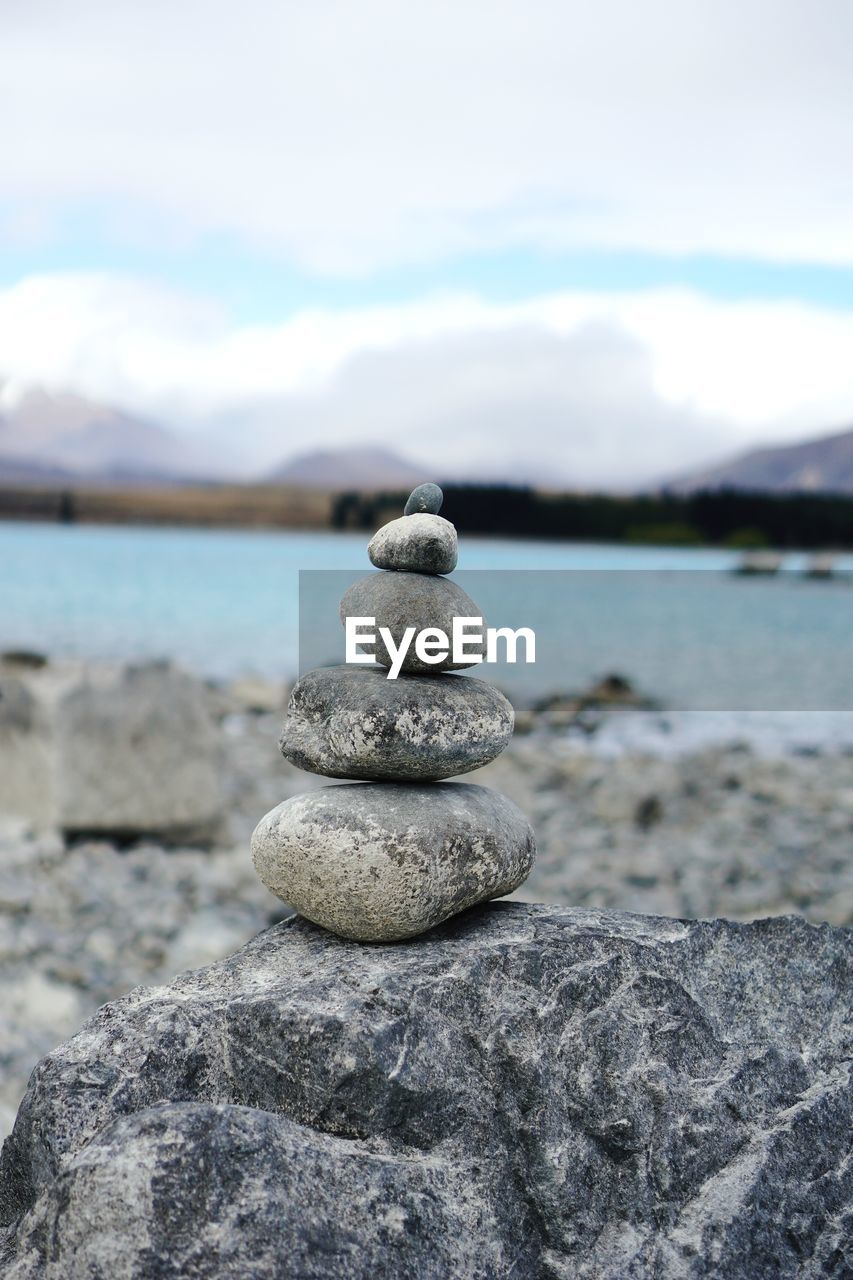 rock, zen-like, balance, sea, water, shore, stone, pebble, nature, beach, tranquility, coast, sky, land, day, no people, focus on foreground, tranquil scene, sand, beauty in nature, cloud, scenics - nature, ocean, outdoors, blue, stability