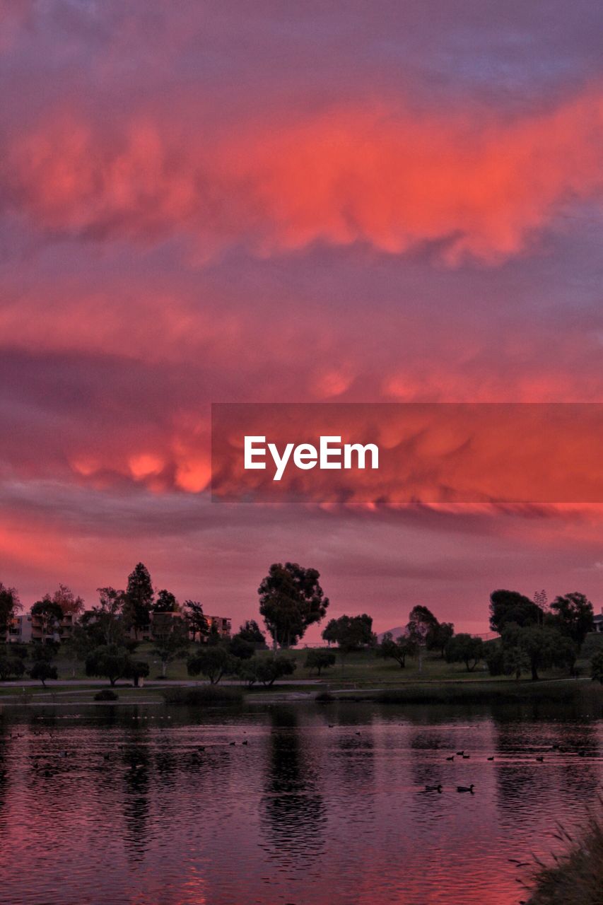 SCENIC VIEW OF LAKE AGAINST ORANGE SKY