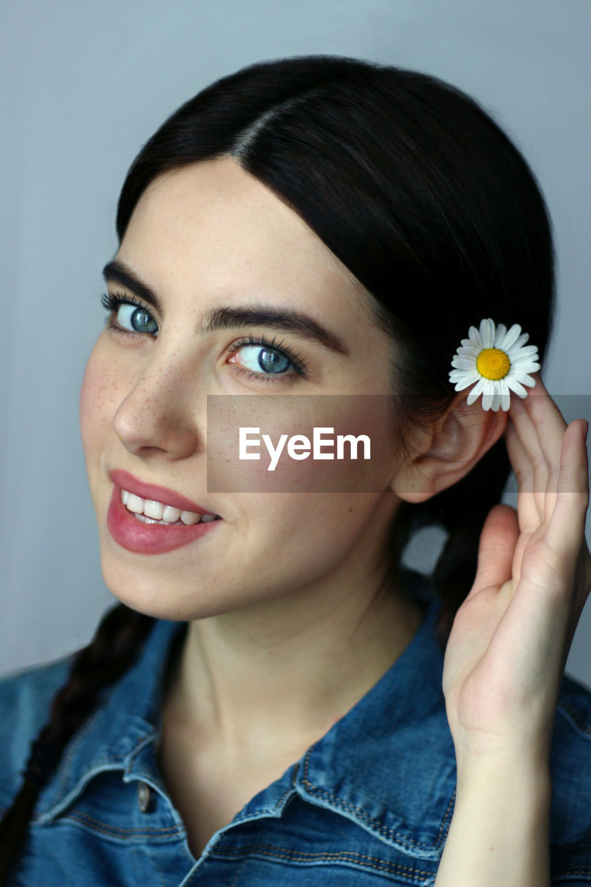 Close-up portrait of a smiling young woman  cute blue eyes jeans 