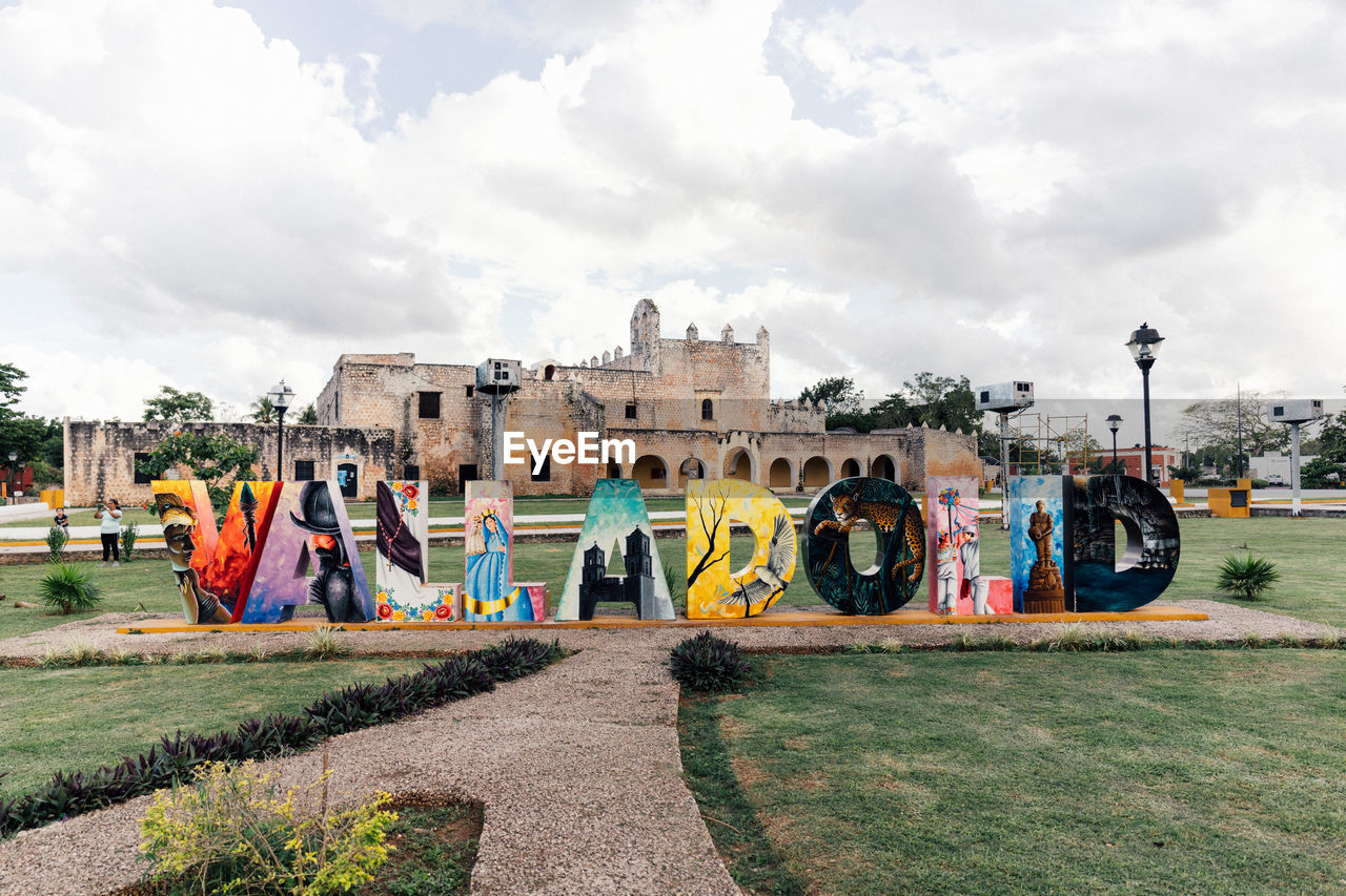 architecture, sky, cloud, graffiti, built structure, city, building exterior, multi colored, nature, playground, creativity, urban area, day, street art, grass, park, building, tree, plant, outdoors, public space, no people, travel destinations, transportation, town, art