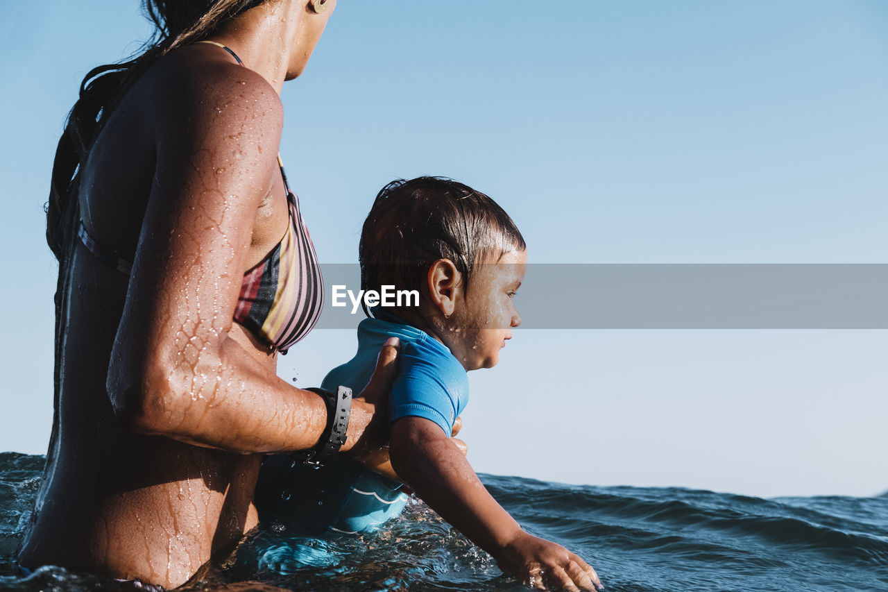 Intimate portrait of mother and baby son at sea