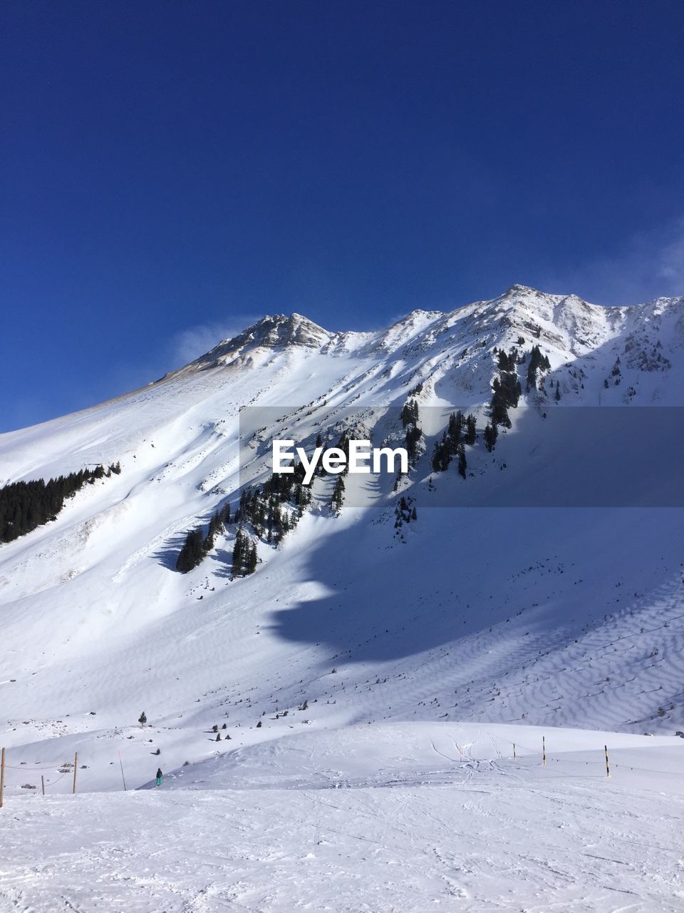 Scenic view of snowcapped mountain against blue sky