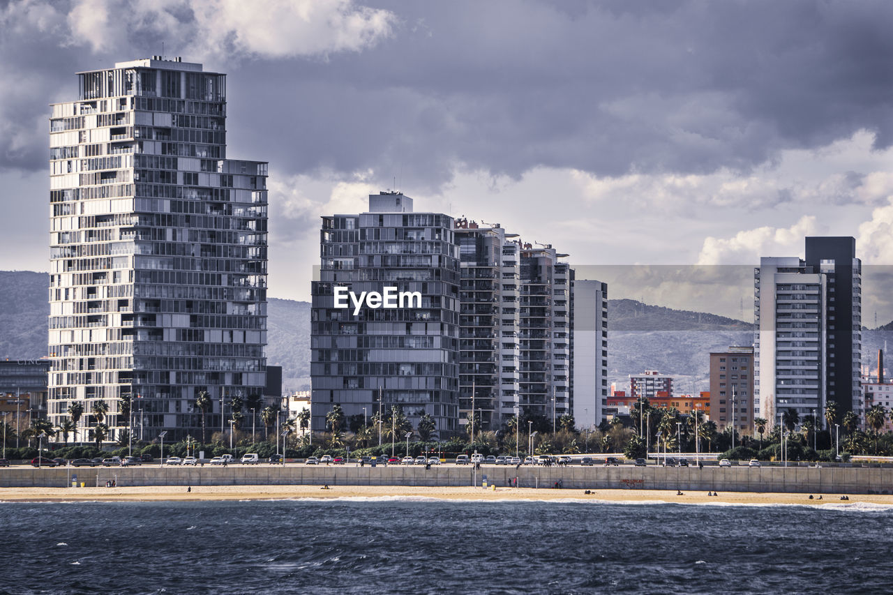 RIVER BY BUILDINGS AGAINST SKY