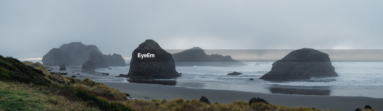 Scenic seascape of sandy beach with sea stacks in fog, meyers creek beach, southern oregon