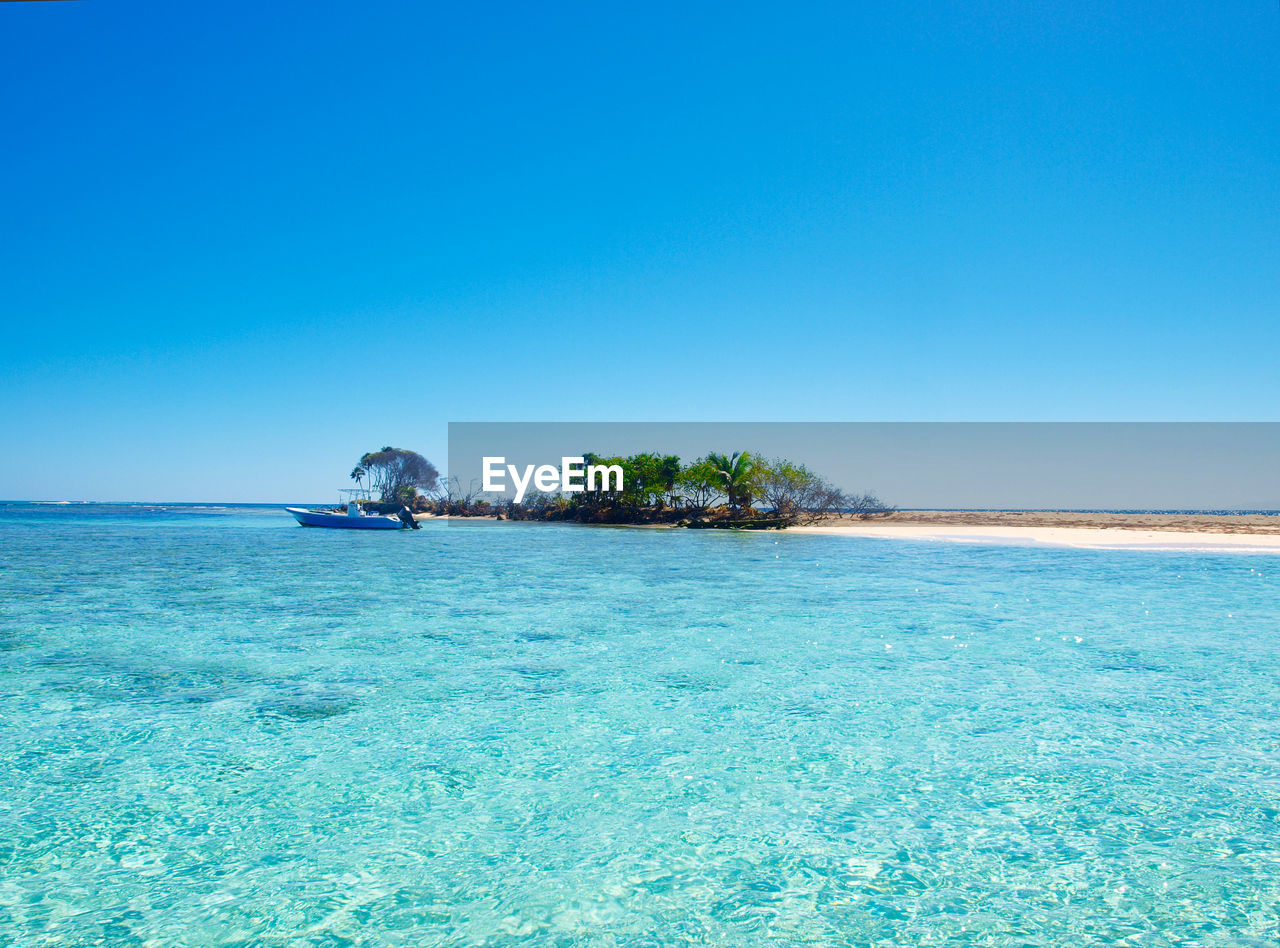 Scenic view of sea against clear blue sky