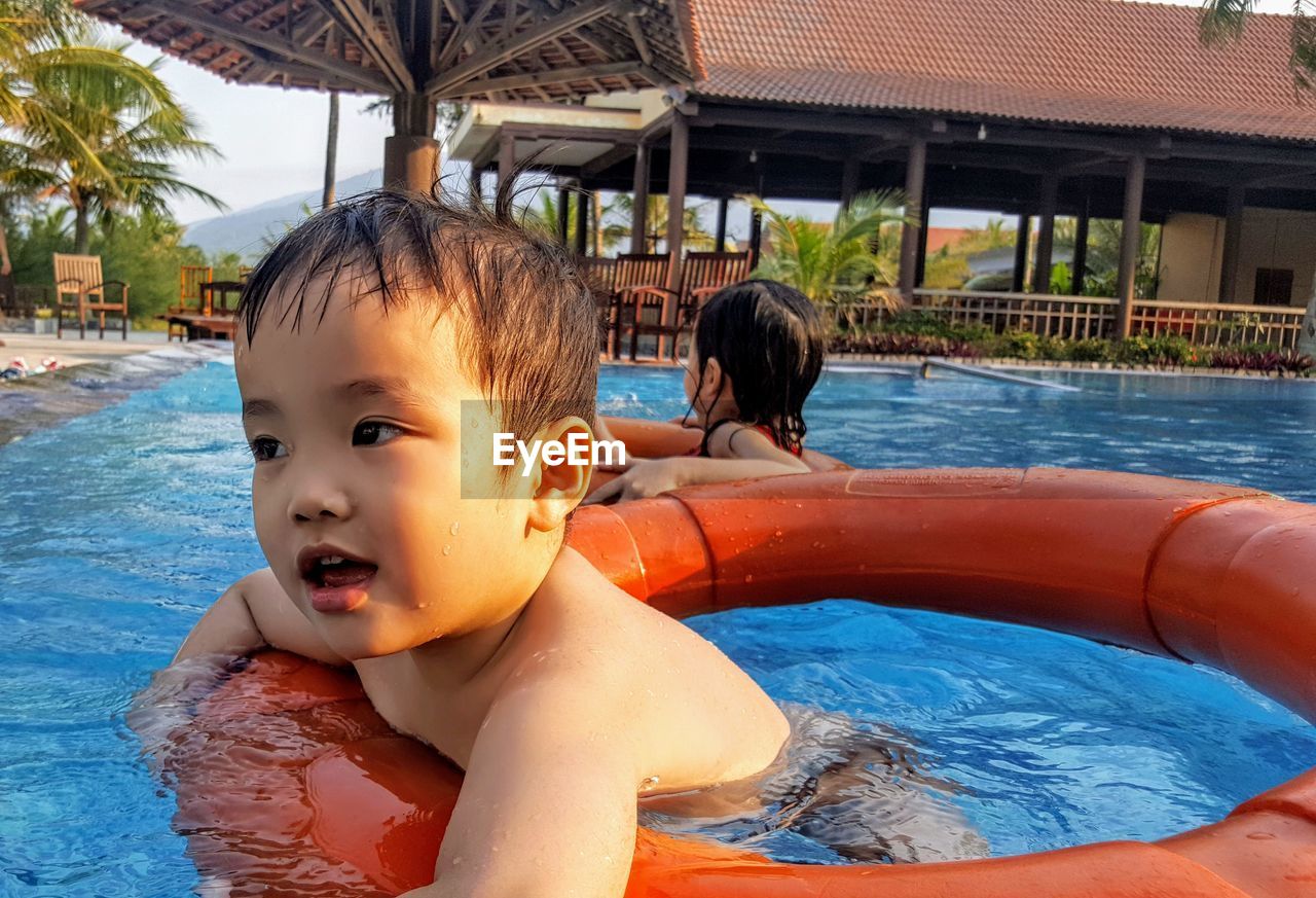 PORTRAIT OF BOY WITH SWIMMING POOL