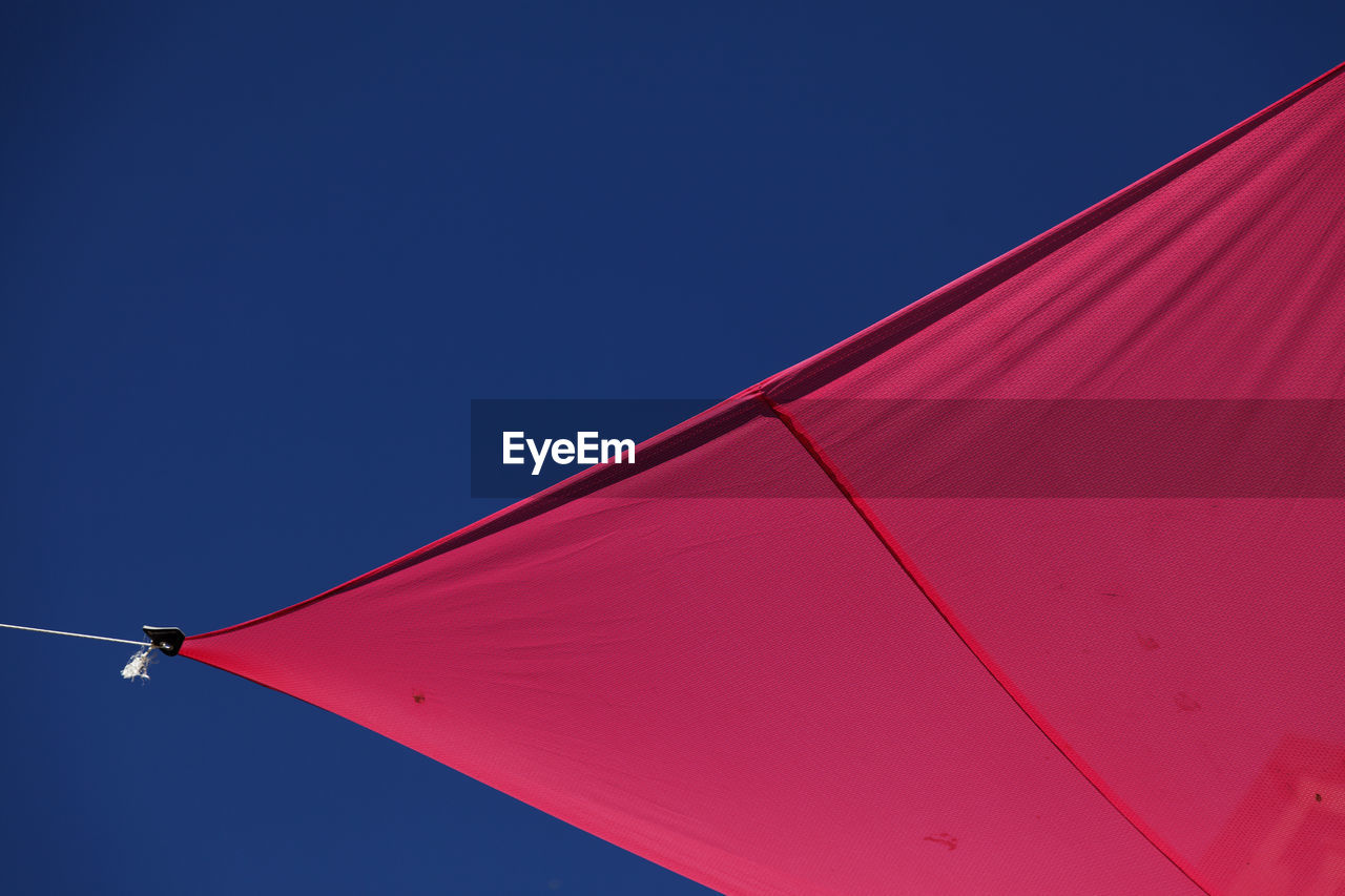 LOW ANGLE VIEW OF RED UMBRELLA AGAINST SKY