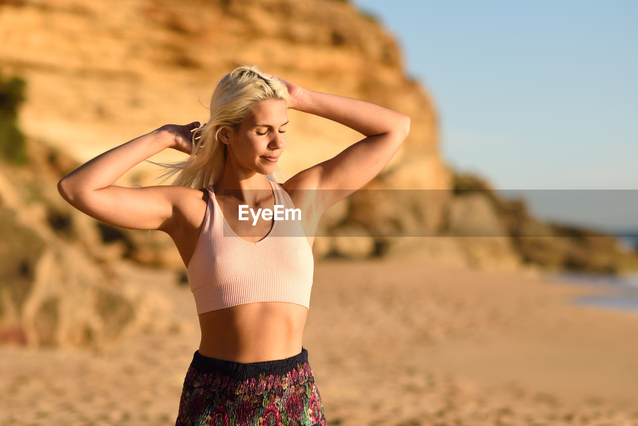 Young woman with eyes closed standing at beach