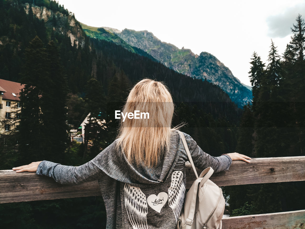 REAR VIEW OF WOMAN LOOKING AT MOUNTAIN RANGE