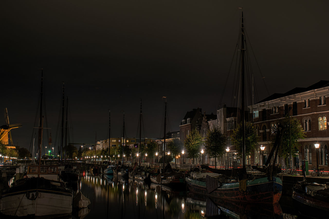 BOATS MOORED AT HARBOR AGAINST SKY IN CITY